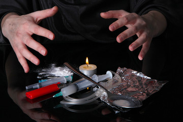 Drug addict with syringe on black background