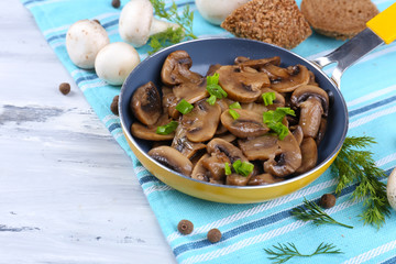 Delicious fried mushrooms in pan on table close-up