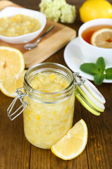 Tasty lemon jam with cup of tea on table close-up