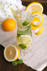 Glass of cocktail with lemon and mint on table close-up