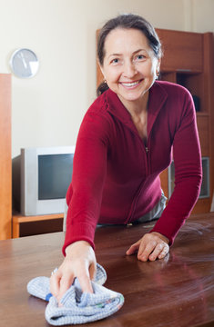 Smiling Mature Woman In Red Cleaning  Table