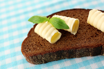 Slice of rye bread with butter, on tablecloth