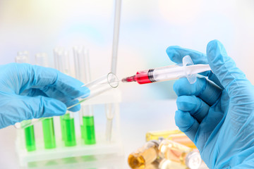 Technician injecting blood sample in test tube analysis,