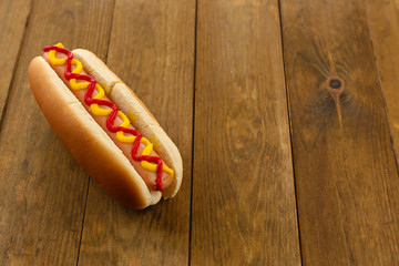 Tasty hot dog on wooden table