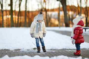 Two little sisters having fun on winter day