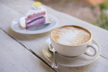 Cup of latte coffee and cake