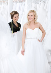 Naklejka premium Professional designer and the bride examine the dress