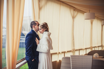 wedding. newlyweds sitting in a cozy cafe in beige scenery