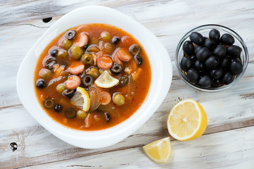 Russian solyanka soup with meat, sausages, olives and lemon
