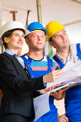 Team auf Baustelle kontrolliert Bau Pläne