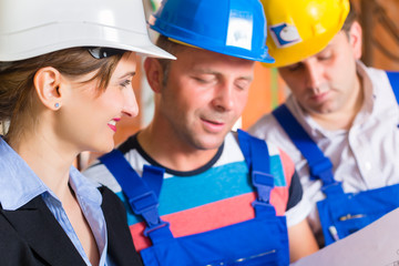 Team auf Baustelle kontrolliert Bau Pläne