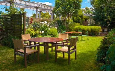 Obraz premium Dining Table set in Lush Landscaped Garden