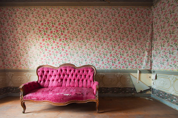 Old damaged red couch in an antique house. Flowers wallpaper - 61238642