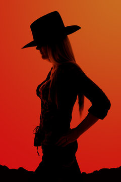 Silhouette of cowgirl with hands on her hips