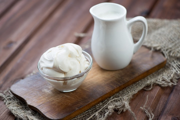 Homemade sour cream or smetana, wooden background