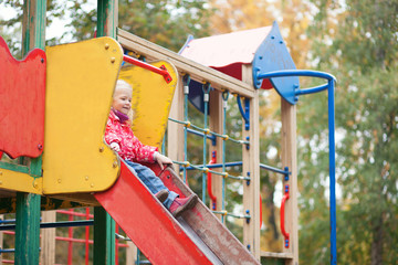 Little girl preparing to slither from a slide