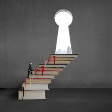 Businessman On Stack Books To Key Shape Door With City View