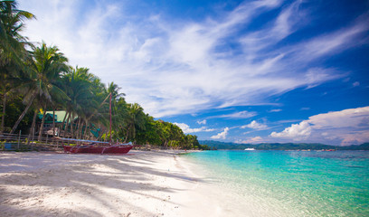 Tropical beach with white sand and a small boat