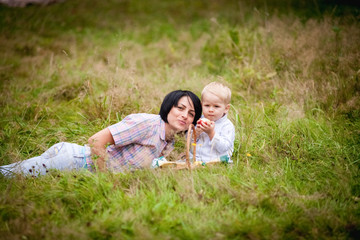 Fototapeta premium Mom and son eating fruit with wicker baskets