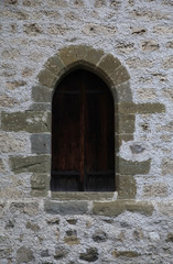 Arch window in old stone wall of medieval castle
