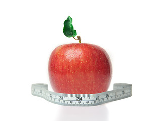 Red apple with green leaf and measuring tape