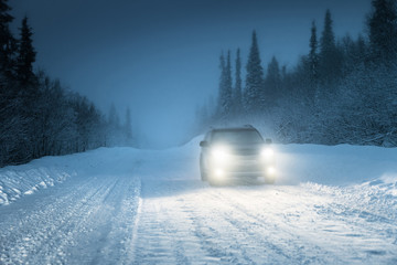 Car lights in winter Russian forest