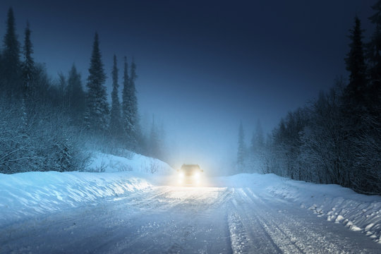 Fototapeta Car lights in winter Russian forest