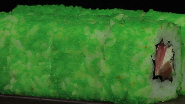 Sushi with green caviar on a black background