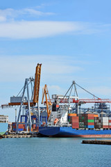 Container stack and ship under crane bridge