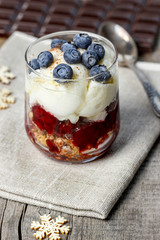 Layer strawberry, blueberry and muesli dessert in glass goblet