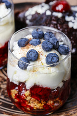 Layer strawberry, blueberry and muesli dessert in glass goblet