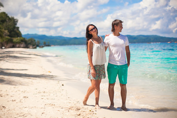 Young couple walking on sandy beach near the sea
