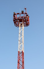 Security tower with spotlight over blue sky background.