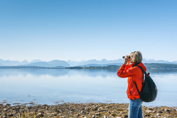 Woman tourist looking through binoculars