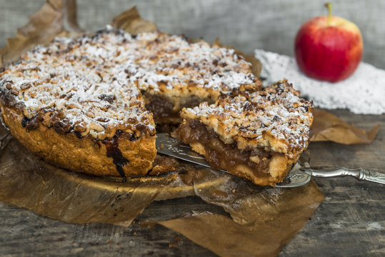 Apple pie and apple on old, rustic wooden table