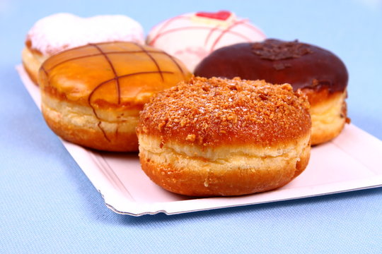 Five delicious, assorted donuts on plate