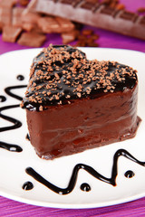 Sweet cake with chocolate on plate on table close-up