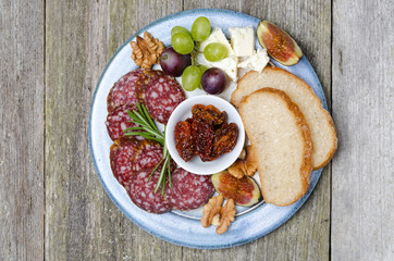 plate of snacks - sausage, bread, figs, grapes, nuts