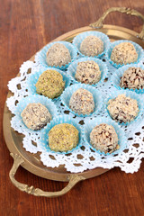 Set of chocolate candies, on tray, on wooden background
