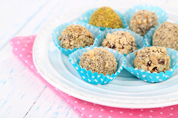 Set of chocolate candies, on plate, on wooden background