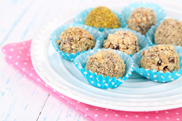 Set of chocolate candies, on plate, on wooden background