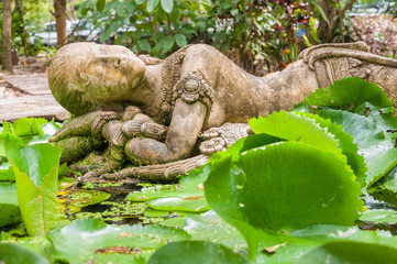 Sleeping stone lady sculpture in public garden