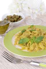 Delicious pasta with pesto on plate on table close-up