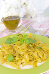 Delicious pasta with pesto on plate on table on light