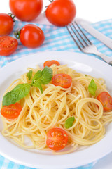 Delicious spaghetti with tomatoes on plate on table close-up