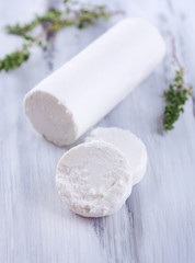 Tasty bushe cheese with thyme, on wooden table