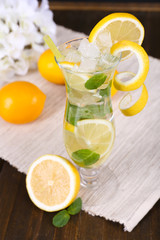 Glass of cocktail with lemon and mint on table close-up