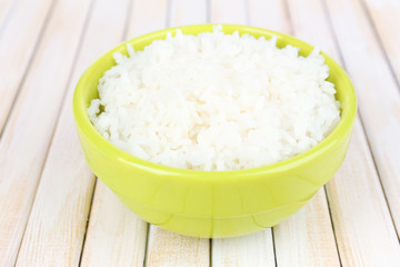 Cooked rice in bowl on wooden background