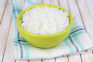 Cooked rice in bowl on wooden background