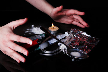 Drug addict with syringe on black background